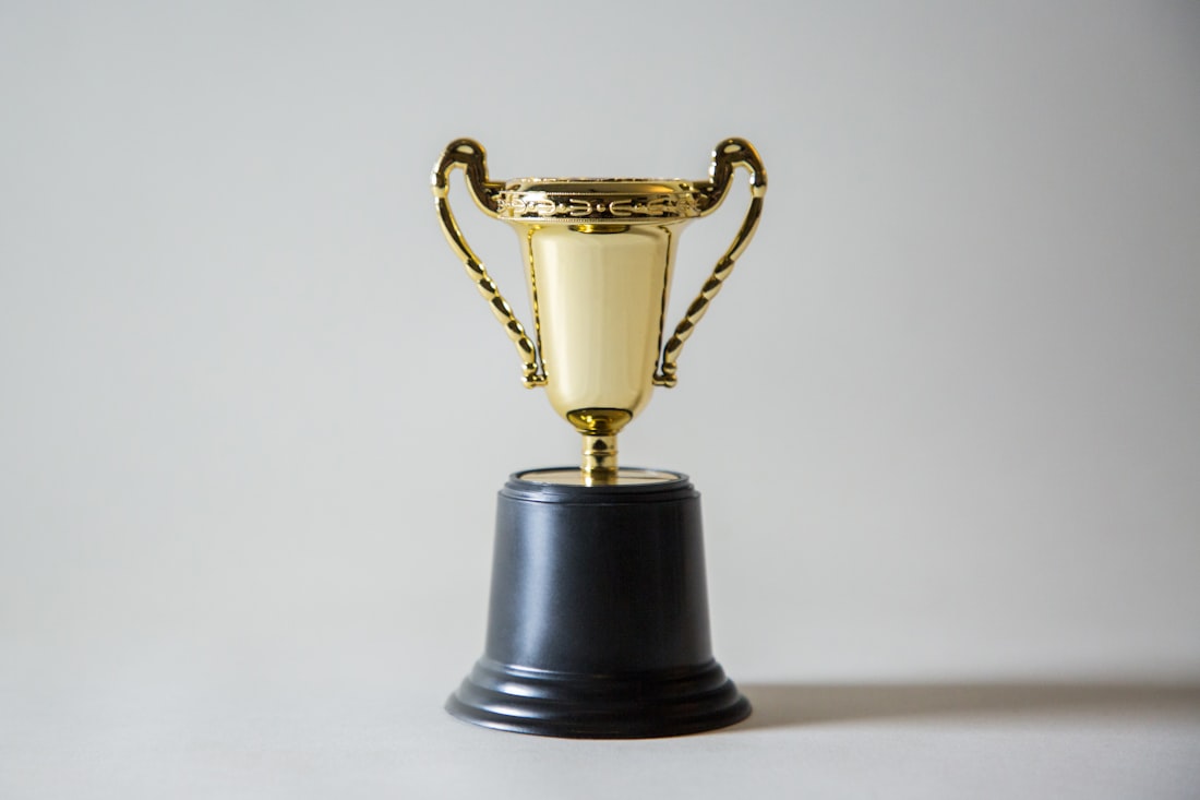 Piala emas di atas meja dengan latar gelap
